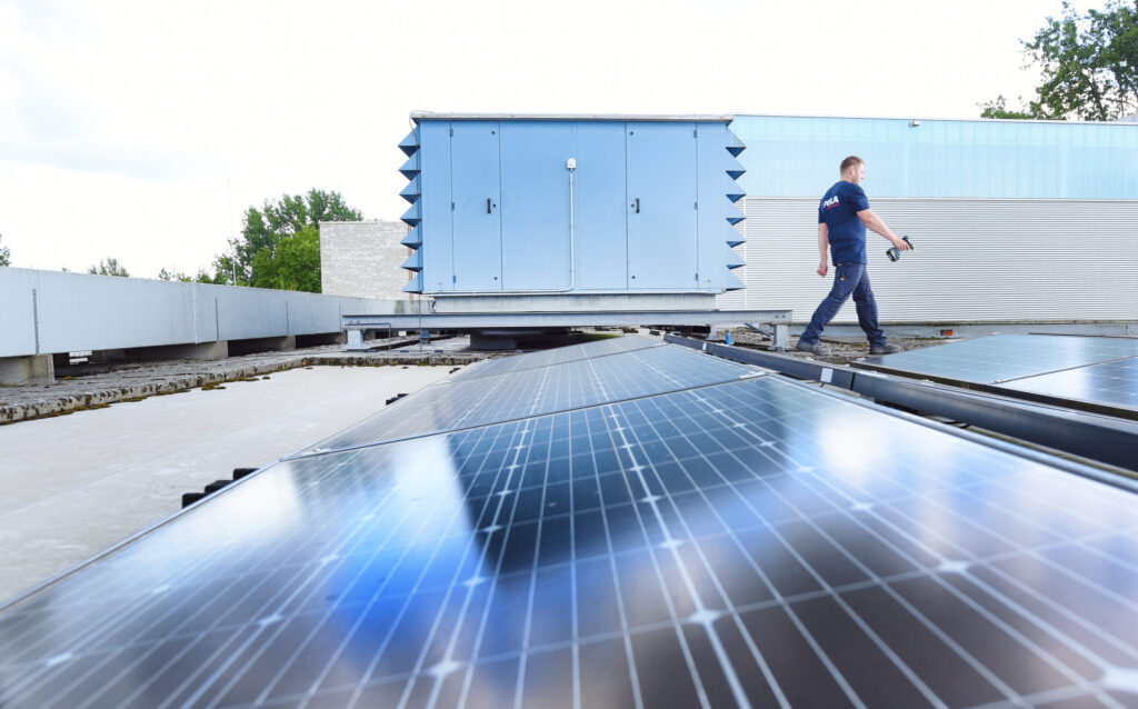 installatie monteur pola op dak van bedrijfspand met zonnepanelen
