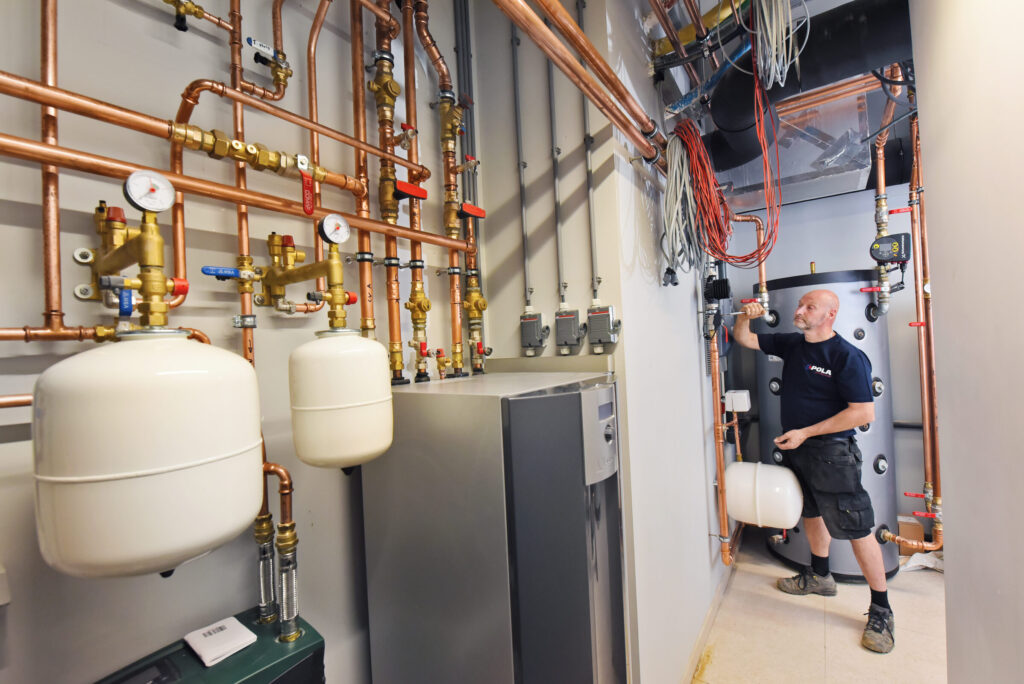 monteur pola in technische ruimte voor onderhoud warmtepomp